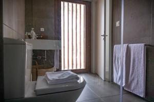 a bathroom with a toilet and a sink and a window at Pestana Troia Eco-Resort & Residences in Troia