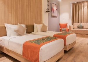 a hotel room with two beds and a couch at Centre Point Navi Mumbai in Navi Mumbai