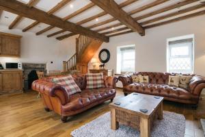uma sala de estar com sofás de couro e uma mesa de centro em Stunning Blackberry Cottage with Log Burner - located on Haworth Main Street em Haworth
