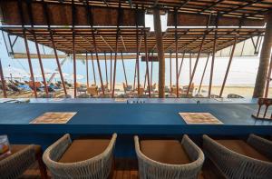 a bar with chairs and the beach in the background at Bandara Spa Resort & Pool Villas, Samui in Bophut