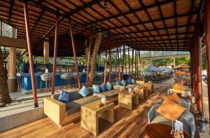 a restaurant with couches and tables in a building at Bandara Spa Resort & Pool Villas, Samui in Bophut