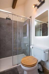 a bathroom with a toilet with a glass shower at Stunning Blackberry Cottage with Log Burner - located on Haworth Main Street in Haworth +34 photos