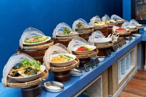 a buffet line with plates of food in plastic wrap at Bandara Spa Resort & Pool Villas, Samui in Bophut