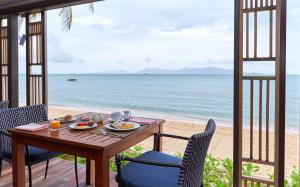 a table and chairs with a view of the beach at Bandara Spa Resort & Pool Villas, Samui in Bophut