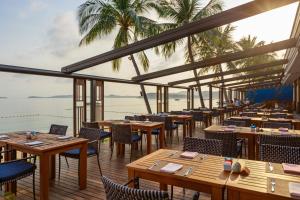 a restaurant with tables and chairs and a view of the ocean at Bandara Spa Resort & Pool Villas, Samui in Bophut