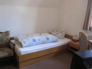 - une petite chambre avec un lit et une chaise dans l'établissement Bei Weirich, à Schwangau