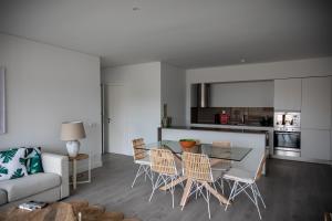 a kitchen and living room with a glass table and chairs at Pestana Troia Eco-Resort & Residences in Troia