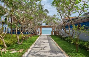 a walkway leading to a house with the ocean in the background at Bandara Spa Resort & Pool Villas, Samui in Bophut