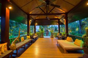 a covered deck with couches and plants on it at Bandara Spa Resort & Pool Villas, Samui in Bophut