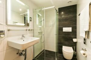 La salle de bains est pourvue d'un lavabo et d'une douche. dans l'établissement City Hotel Heilbronn, à Heilbronn