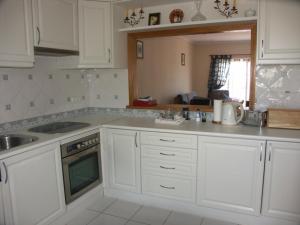 a kitchen with white cabinets and a sink at 12 A Clube Golfemar in Carvoeiro
