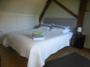 um quarto com uma cama branca e toalhas em La Maison du Closier em Blois