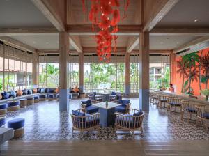 a lobby with tables and chairs and a chandelier at Bandara Spa Resort & Pool Villas, Samui in Bophut