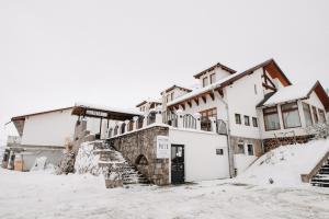 オドルヘユ・セクイエスクにあるPáva Pension & Spaの雪中の大きな白い建物