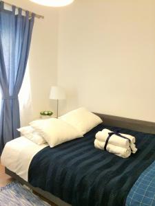 a bedroom with a bed with towels on it at Simply@Home in Setúbal
