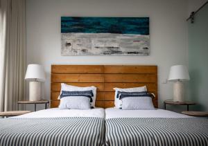 two beds sitting next to each other in a bedroom at Pestana Troia Eco-Resort & Residences in Troia