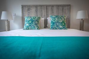 a bed with blue and white pillows in a bedroom at Pestana Troia Eco-Resort & Residences in Troia
