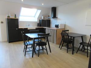 uma cozinha com mesas pretas e cadeiras num quarto em Les Bordes em Vineuil