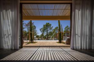 an open door to a patio with trees at Pestana Troia Eco-Resort & Residences in Troia