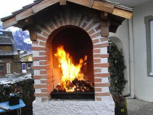a brick fireplace with a fire in it at Hotel zum Toni in Bad Hofgastein