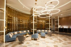 eine Lobby mit blauen Sofas und einem Kronleuchter in der Unterkunft The Quarter Ladprao by UHG in Bangkok