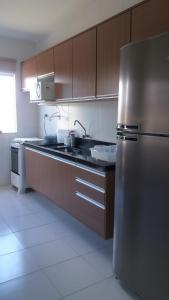 Una cocina con refrigerador y gabinetes de acero inoxidable. en Casa Recanto de Guarajuba, en Guarajuba