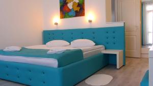 a bed with a blue headboard in a room at Casa OK by OVO in Vama Veche +55 photos