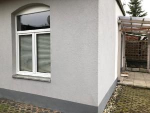 een wit huis met een raam en een patio bij Ferienwohnung A.Engelhardt in Nordhausen