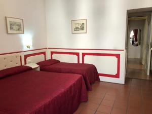 ローマにあるスターテルミニのベッド2台と廊下が備わるホテルルームです。