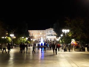 アテネにあるΑthens Flat at Syntagma Squareの夜の広場を歩く人々