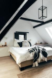 a bedroom with a large bed in a attic at Maison Francois in Varsenare