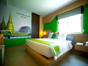 een slaapkamer met een groot bed met een groene muur bij Ds67 Suites in Bangkok