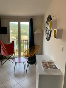 - un salon avec une table, des chaises et une horloge dans l'établissement T3 Duplex tout confort - piscine - proche plage - 6 personnes, à Palasca