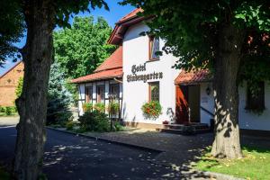 a white building with a red roof at Hotel & Restaurant Lindengarten in Lübben