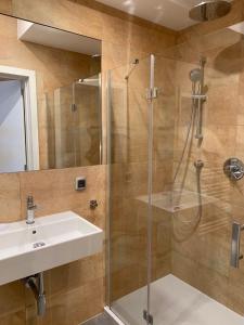 uma casa de banho com um lavatório e um chuveiro em Apartament na Klifie DUNE em Ustronie Morskie