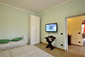 een slaapkamer met een bed en een televisie aan de muur bij Casa Malìca in Perugia