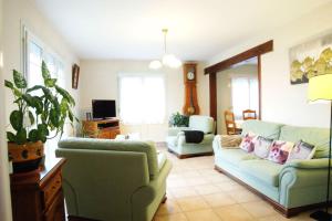 a living room with two couches and a tv at Chez Karinette in Les Rivières-Henruel