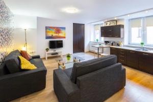 a living room with a couch and a kitchen at Wawel Cracow Old City Apartments - Friendhouse Apartments in Krakow