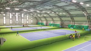 - un court de tennis avec des personnes sur place dans l'établissement Sport Hotel Gejzirpark, à Karlovy Vary