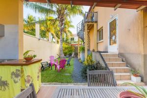 une terrasse avec des chaises et une table ainsi qu'une maison dans l'établissement La Kaz à l'Étang - Votre Location de Vacances à l'Île de La Réunion, à Saint-Louis