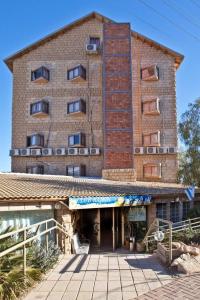 a large brick building with windows and a staircase at Hotel Club Ramon in Mitzpe Ramon
