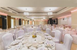 a banquet hall with white tables and white chairs at Torreluz Centro in Almería