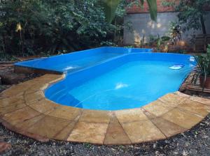 a swimming pool in a backyard with blue water at Arboleda in Jardín América