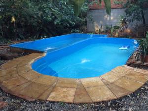 una piscina en un patio trasero con agua azul en Arboleda en Jardín América