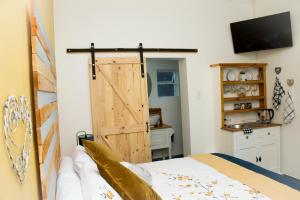 Un dormitorio con una puerta corredera de granero y una cama en A Touch of Grace, en Potchefstroom