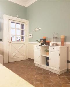 - une cuisine avec une armoire blanche et une porte dans l'établissement B&B Delle Palme, à Naples