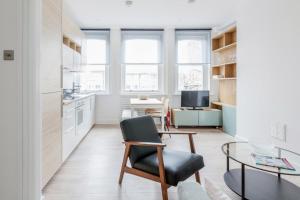 a kitchen with a table and a chair in a room at Live like a Londoner by TOWER BRIDGE in London