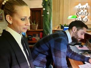 a woman standing next to a man at a desk at Albergo delle Drapperie in Bologna