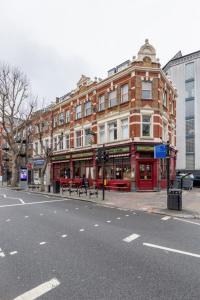 een rood bakstenen gebouw aan de kant van een straat bij Live like a Londoner by TOWER BRIDGE in Londen