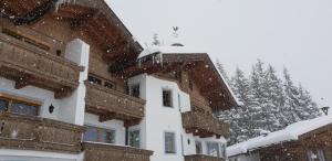 a snow covered roof of a house with snow falling at Chalet Bergzauber by PiaundDirk in Hippach